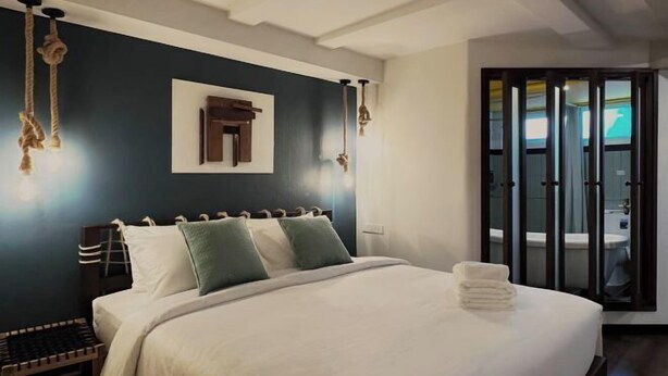 A bedroom with a bed, pillows, a bedside table, and a hanging light fixture. - Belivin'98 Sense of Pier Sathon Residence (Bangkok)