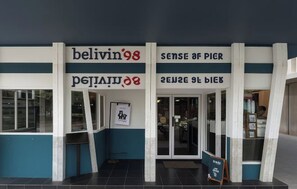 A building facade with signage for 'belivin98' and 'sense of pier'.