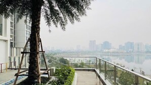 A balcony with a view of a river and cityscape. - Vinhomes Skylake Ha Noi Services Apartments - GalaxyHouse (Hanoi)