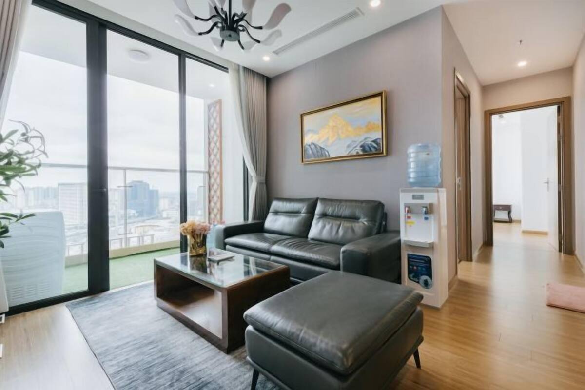 Uma sala de estar moderna com um sofá de couro, uma mesa de centro e uma janela ampla com vista para a cidade.