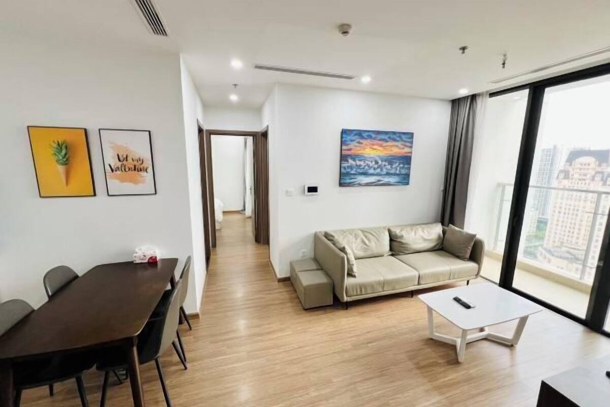 Uma sala de estar moderna com um sofá, uma mesa de centro e uma área de jantar com cadeiras e uma mesa.