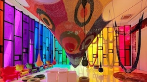 A vibrant room with colorful walls, a hanging chair, and a hammock. - Arte Mont Kiara By Yan Yee (Kuala Lumpur)
