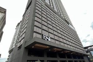 Ein hohes Gebäude mit einer gitterförmigen Fassade, auf deren Unterseite die Buchstaben 'ESI' gut sichtbar angebracht sind.