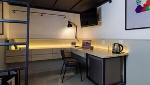 A compact kitchenette with a desk, chair, and a small cabinet. - Upstairs Downstairs CoLiving Bukit Bintang (Kuala Lumpur)