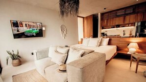 Un dormitorio moderno con cama, sofá, escritorio y una zona de cocina.