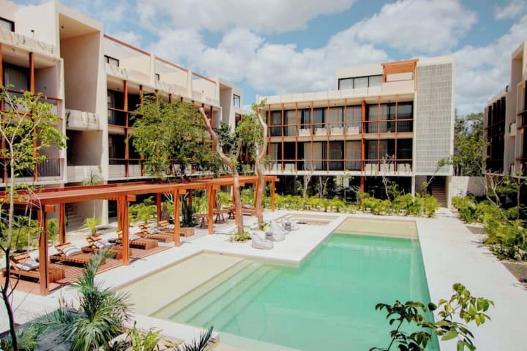 Un hôtel moderne doté d’une piscine, d’un espace extérieur aménagé et d’une terrasse couverte.