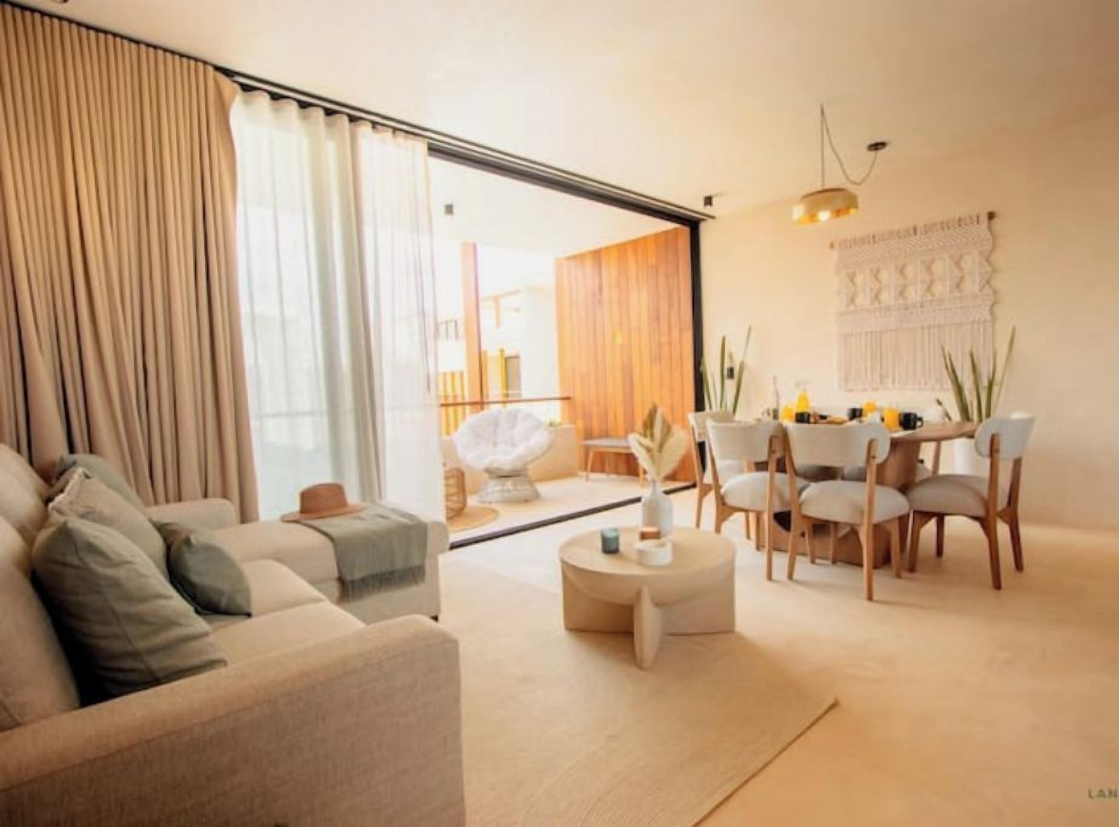 A modern living room with a sofa, round coffee table, and dining area with chairs.
