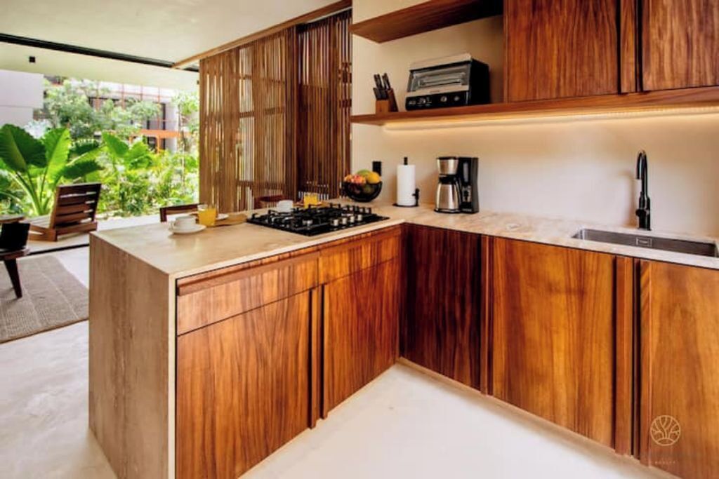 A modern kitchen with wooden cabinets, a gas stove, and a coffee maker.