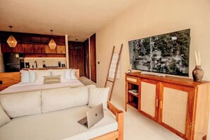 Ein modernes Schlafzimmer mit einem großen Bett, einer Couch, einem Fernseher und einem Holzschrank.