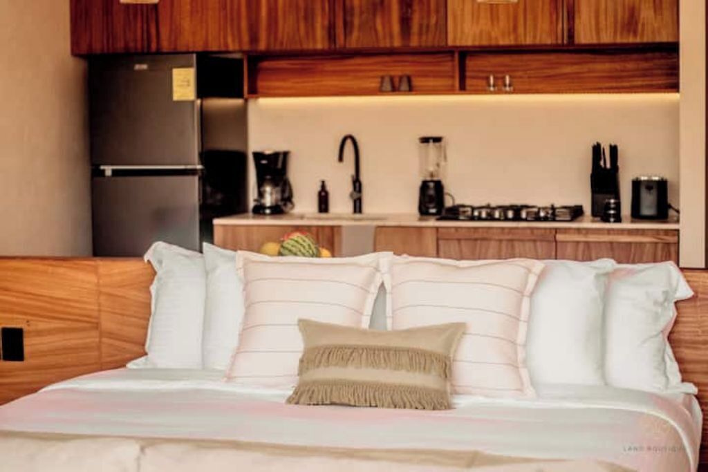 A bedroom with a bed, pillows, and a bedside table.