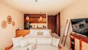 Una camera da letto con un letto, una testiera in legno, una TV e un quadro appeso al muro.