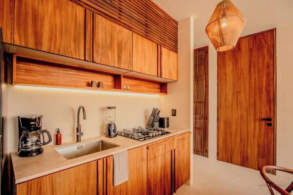 Eine moderne Küche mit Holzschränken, einer eingebauten Spüle und einem Gasherd.