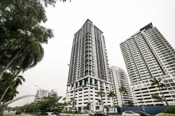 A high-rise building with multiple floors, surrounded by trees and other buildings. - Liwan, Baysuite by Ayuhouz (Kota Kinabalu)
