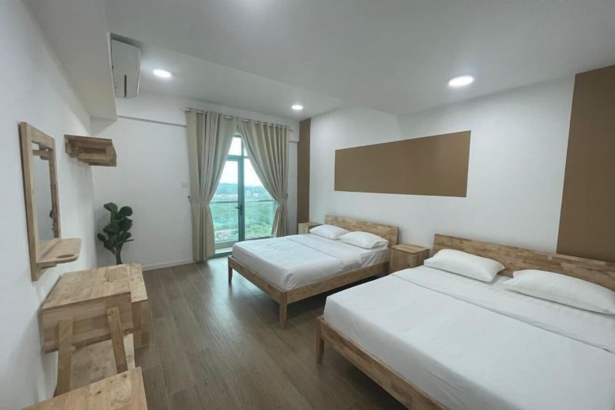 A hotel room with two beds, a desk, a chair, a window with curtains, and a view of the outdoors.