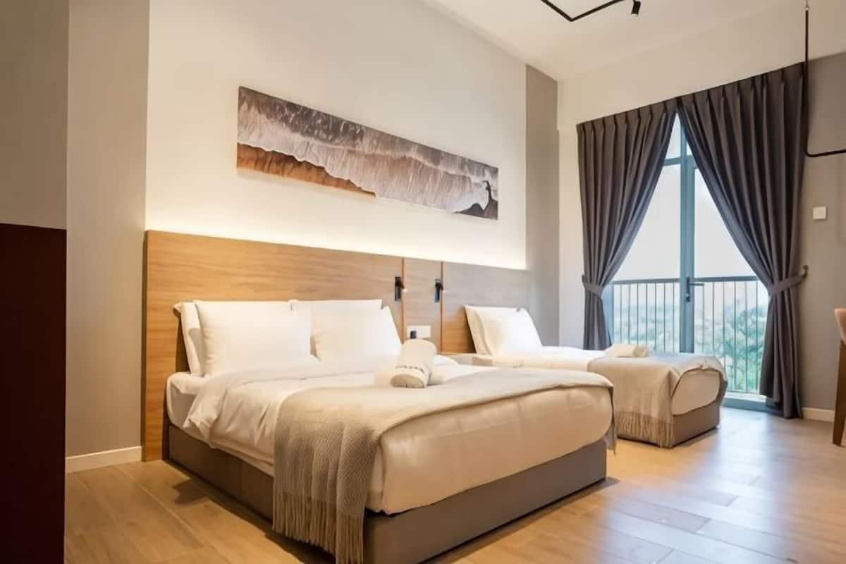 A modern hotel room with a large bed, a bedside table, a wall-mounted artwork, and a large window with curtains.