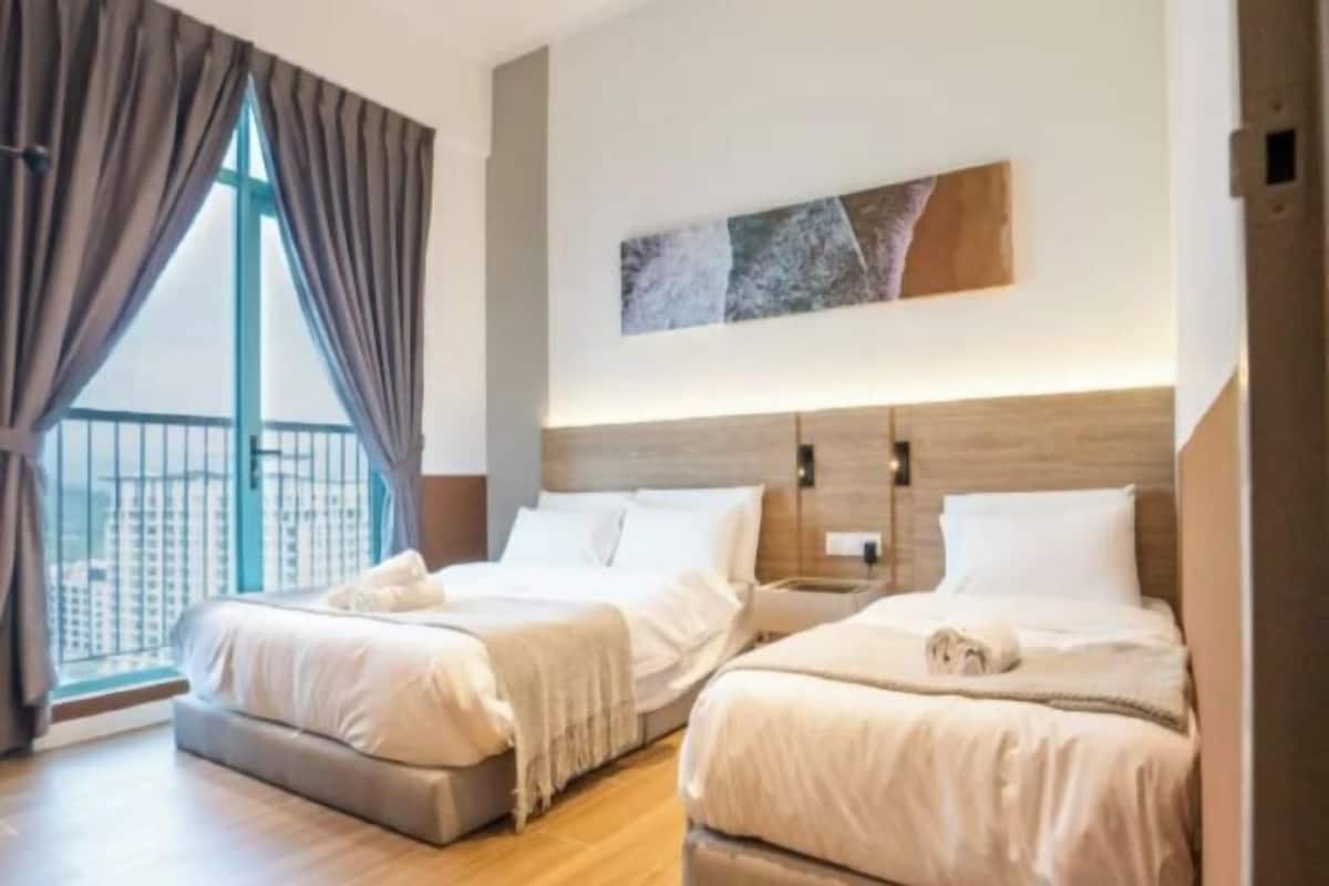 A hotel room with two beds, a large window with curtains, a modern headboard, and a city view.