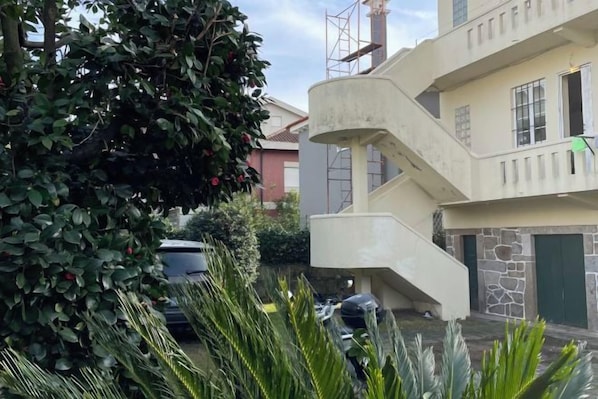 A multi-story building with a central staircase, a car parked in the driveway, and a tree with red berries. - Imaculada Home Royal - Centro de Braga, Historico (Braga)