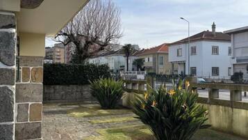Zona residencial con patio empedrado, muro de piedra y vista a la calle.