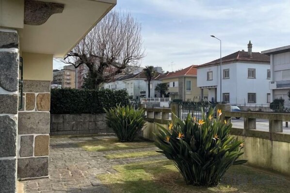 Un quartier résidentiel doté d’une terrasse dallée, d’un mur en pierre et donnant sur la rue.