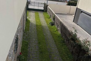 A narrow paved pathway with grass on one side and a stone wall on the other. - Imaculada Home Royal - Centro de Braga, Historico (Braga)