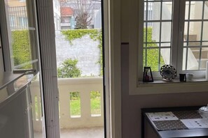 A room with a view of a balcony, a window with a decorative item, and a table with a placemat. - Imaculada Home Royal - Centro de Braga, Historico (Braga)