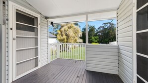 A covered porch with a view of a garden and trees. - Beachfront Escape Relaxing Getaway in Batehaven (Batehaven)