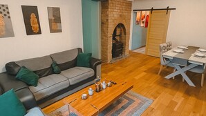A living room with a sofa, coffee table, and fireplace. There is a dining area with a table and chairs. - Entire luxury home free parking - Discount for long stays and contractors (Birmingham)