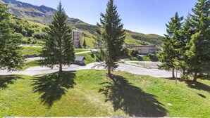Un hôtel doté d’un parking, entouré d’arbres et offrant une vue sur un paysage montagneux.