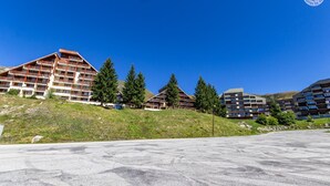 Un hôtel moderne composé de plusieurs bâtiments, chacun doté de balcons et offrant une vue sur un paysage montagneux.