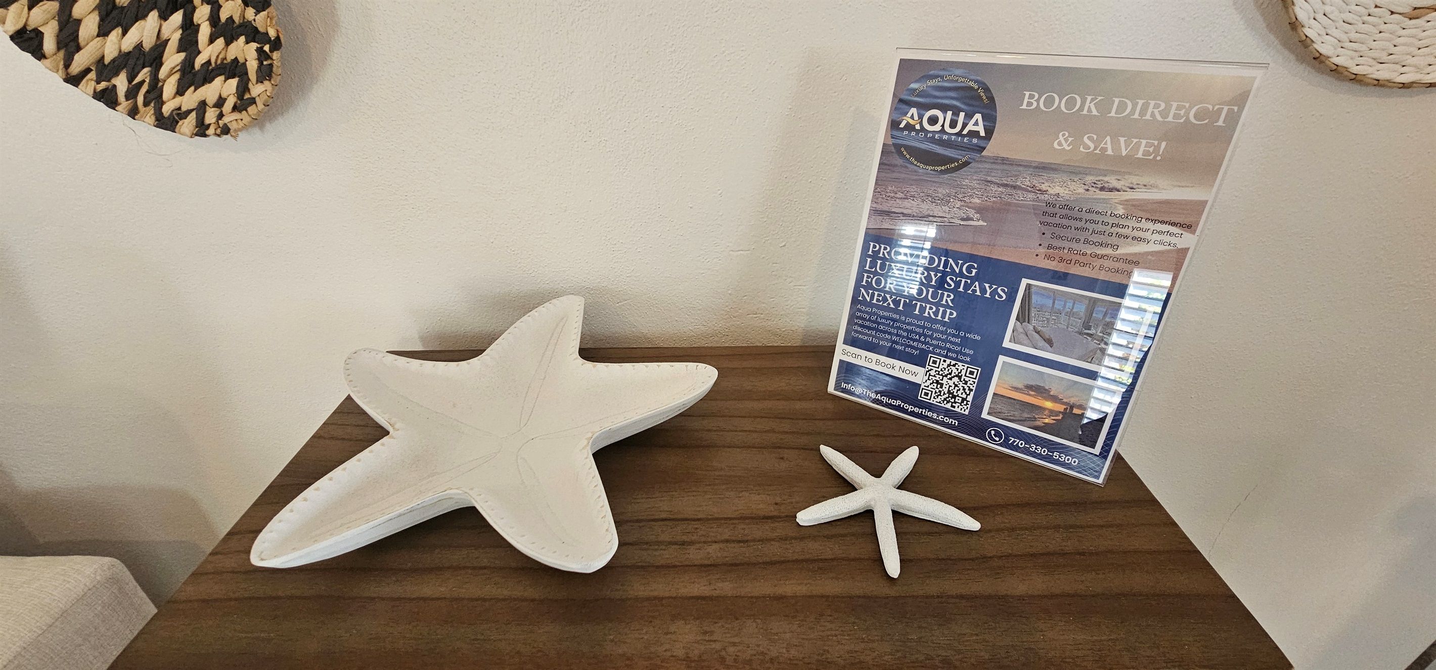 Een houten tafel met een zeester decoratie en een brochure van Aqua Properties.
