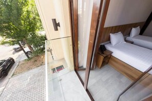 A modern bedroom with a glass balcony, a bed, and a small wooden nightstand. - Centrum Hotel Tashkent (Tashkent)