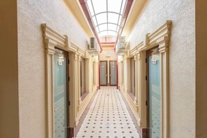 A hotel hallway with a tiled floor, double doors, and a skylight. - Centrum Hotel Tashkent (Tashkent)