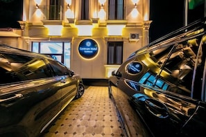 A hotel entrance with two cars parked in front, a sign reading 'Centrum Hotel,' and a patterned floor. - Centrum Hotel Tashkent (Tashkent)