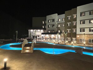 Una piscina al aire libre, camas de piscina gratis, sombrillas