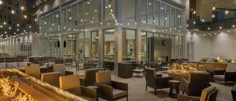 An outdoor seating area with wicker furniture and a fire feature.