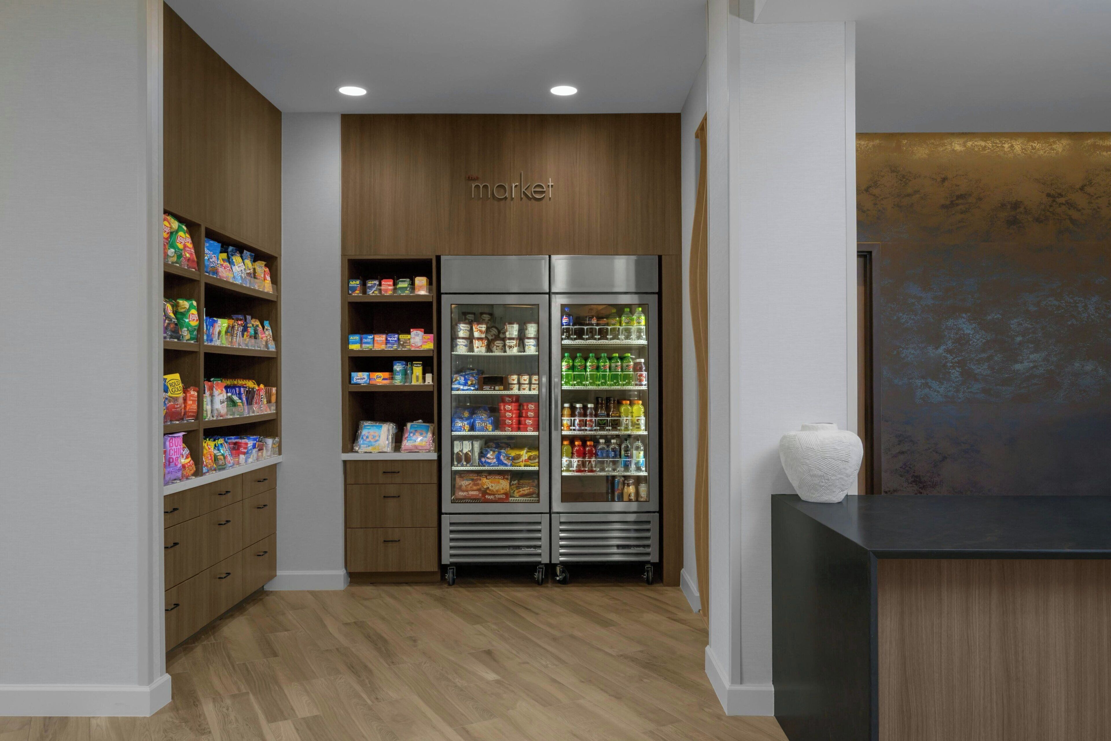 Una kitchenette con armarios de madera, un refrigerador y una encimera con un florero.