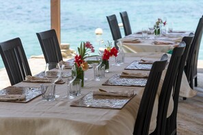 A table set for dining with chairs, a view of the sea, and a tablecloth. - Hotel and restaurant in Bequia (Bequia)