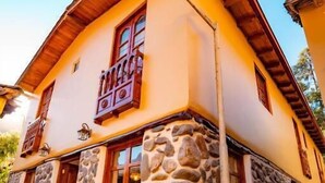 Un edificio de dos pisos de piedra con fachada de madera y cimientos de piedra.