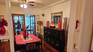 A dining area with a wooden table, chairs, and a ceiling fan.