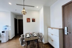 Una zona de menjador moderna amb una taula preparada per a quatre, un dispensador d'aigua i un terra de fusta.