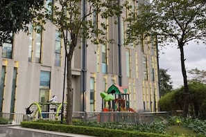 A modern building with a playground in the foreground.