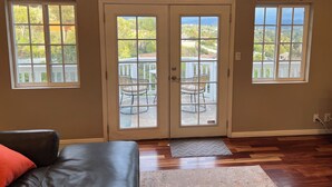 A room with a large sliding glass door leading to an outdoor patio with a table and chairs.