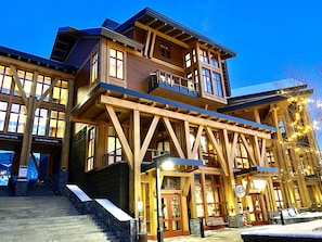 Un bâtiment en bois à plusieurs étages, doté d’un balcon, d’un escalier menant à l’entrée et d’une enseigne indiquant  « Pistes pour débutants ».