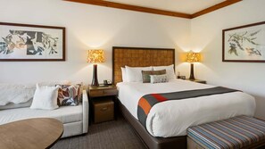 Une chambre d’hôtel avec un grand lit, un canapé, une petite table et deux lampes de chevet.