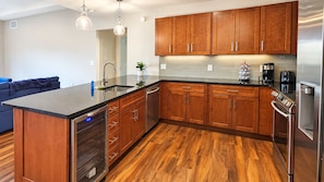 A modern kitchen with wooden cabinets, stainless steel appliances, and a central island. - Spacious! Casino, R&R, Stadiums (Cleveland)