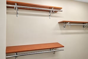 Una pared con tres estantes de madera sujetos a soportes metálicos.