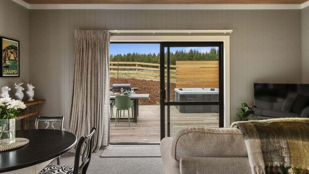 A modern living room with a sliding glass door leading to an outdoor patio.
