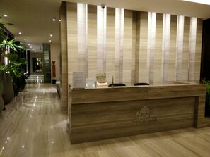 A reception desk with a wooden finish and a vertical striped panel design. - Zire Wonamat - Luxury Large One BR Seaview Apartment, Pattay Beach (Pattaya)