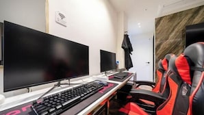 Una configuración para juegos con dos monitores, un teclado y sillas de juego rojas.