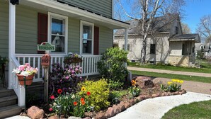 A house with a front porch, a mailbox, and a street sign.